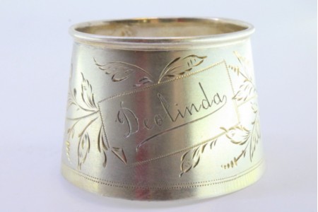 Argola de guardanapo em prata em forma de punho e relevada com motivos florais e duas aplicações relevadas